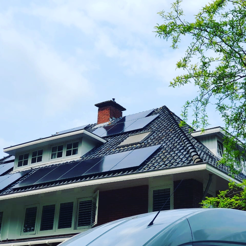 Strak gemonteerde zonnepanelen op meerdere dakvlakken van een villa