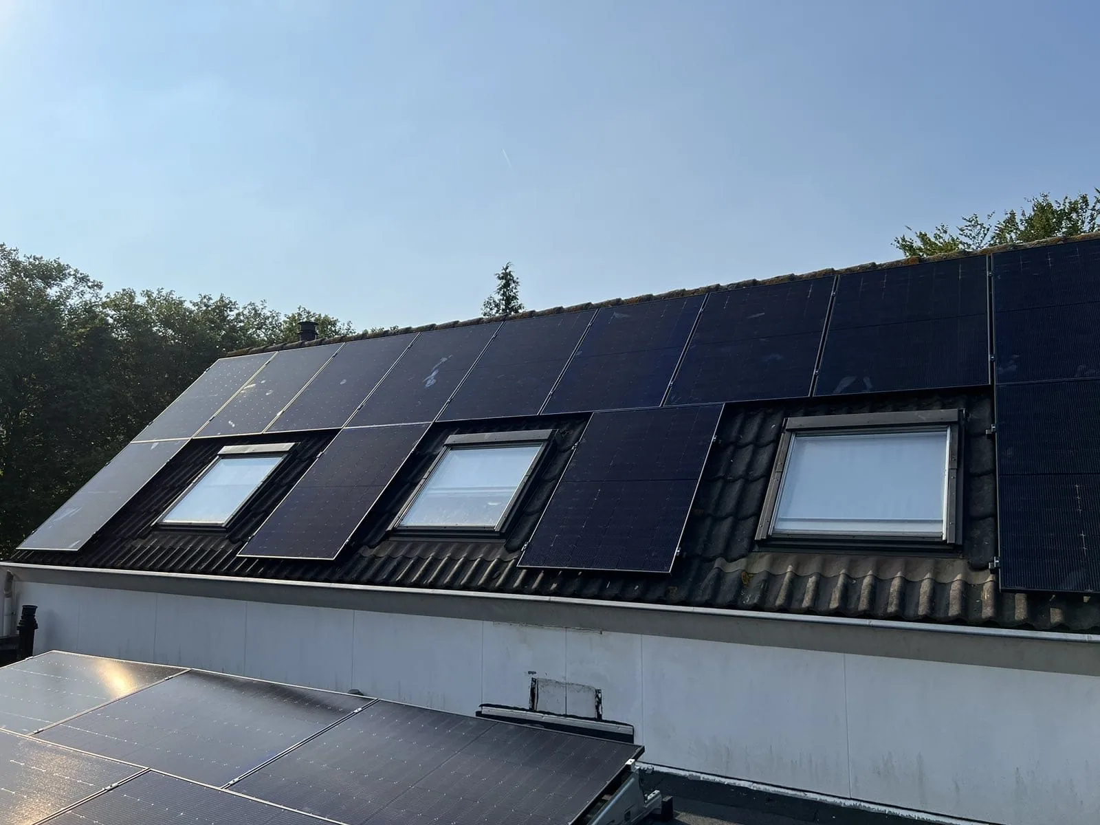 Zonnepanelen op een schuin en plat dak met meerdere dakramen