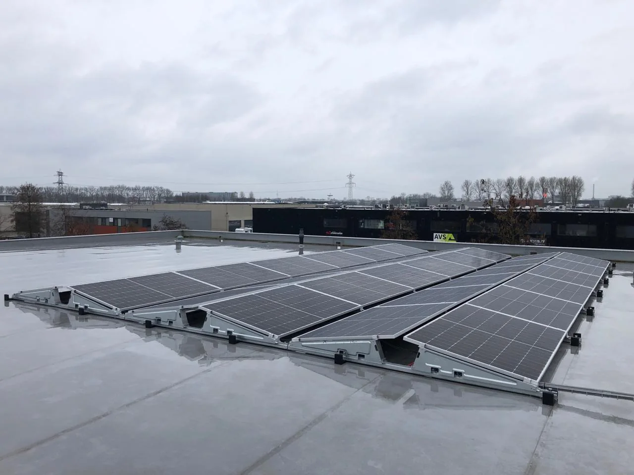 Grote oost-westopstelling met zonnepanelen op een plat bedrijfsdak