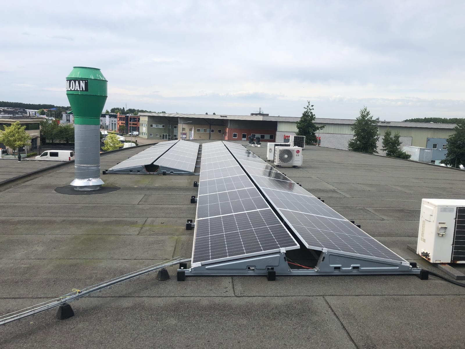 Oost-west-opstelling zonnepanelen op het platte dak van een bedrijfshal